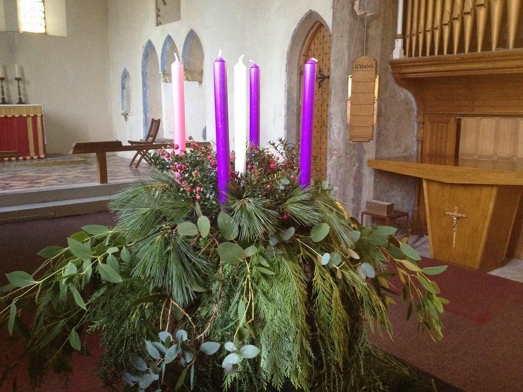 An Advent wreath with four candles, progressively lit, symbolizing growing light in darkness